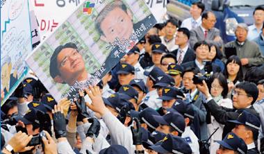 2008 年三星前總裁李健熙(圖中海報右者)涉嫌逃稅、行賄下台,民眾上街抗議財閥惡勢力橫著走(圖中海報左者為三星現任總裁李在鎔)。 2008 年三星前總裁李健熙(圖中海報右者)涉嫌逃稅、行賄下台,民眾上街抗議財閥惡勢力橫著走(圖中海報左者為三星現任總裁李在鎔)。