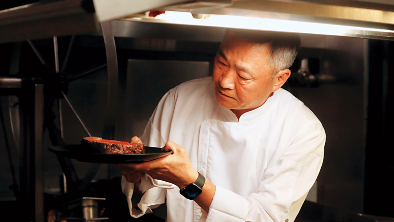 「台灣牛排教父」鄧有癸拿著自家餐廳剛出爐的牛排,仔細盤點外觀形狀、確認中心溫度,就連做外送生意也確保不讓料理品質打折。 「台灣牛排教父」鄧有癸拿著自家餐廳剛出爐的牛排,仔細盤點外觀形狀、確認中心溫度,就連做外送生意也確保不讓料理品質打折。