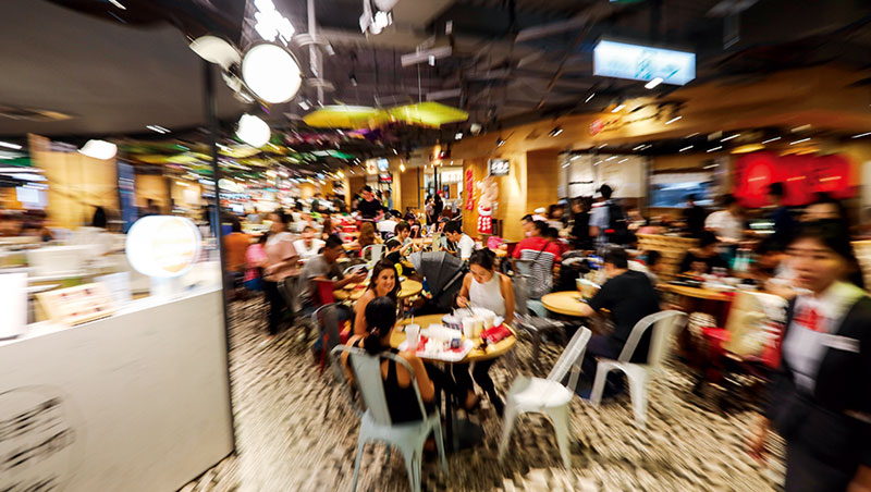 用餐時段，民眾穿梭在公共客席、外帶小攤與店中店之間覓食。混搭組合的各式店型，是新形態美食街最大特色。